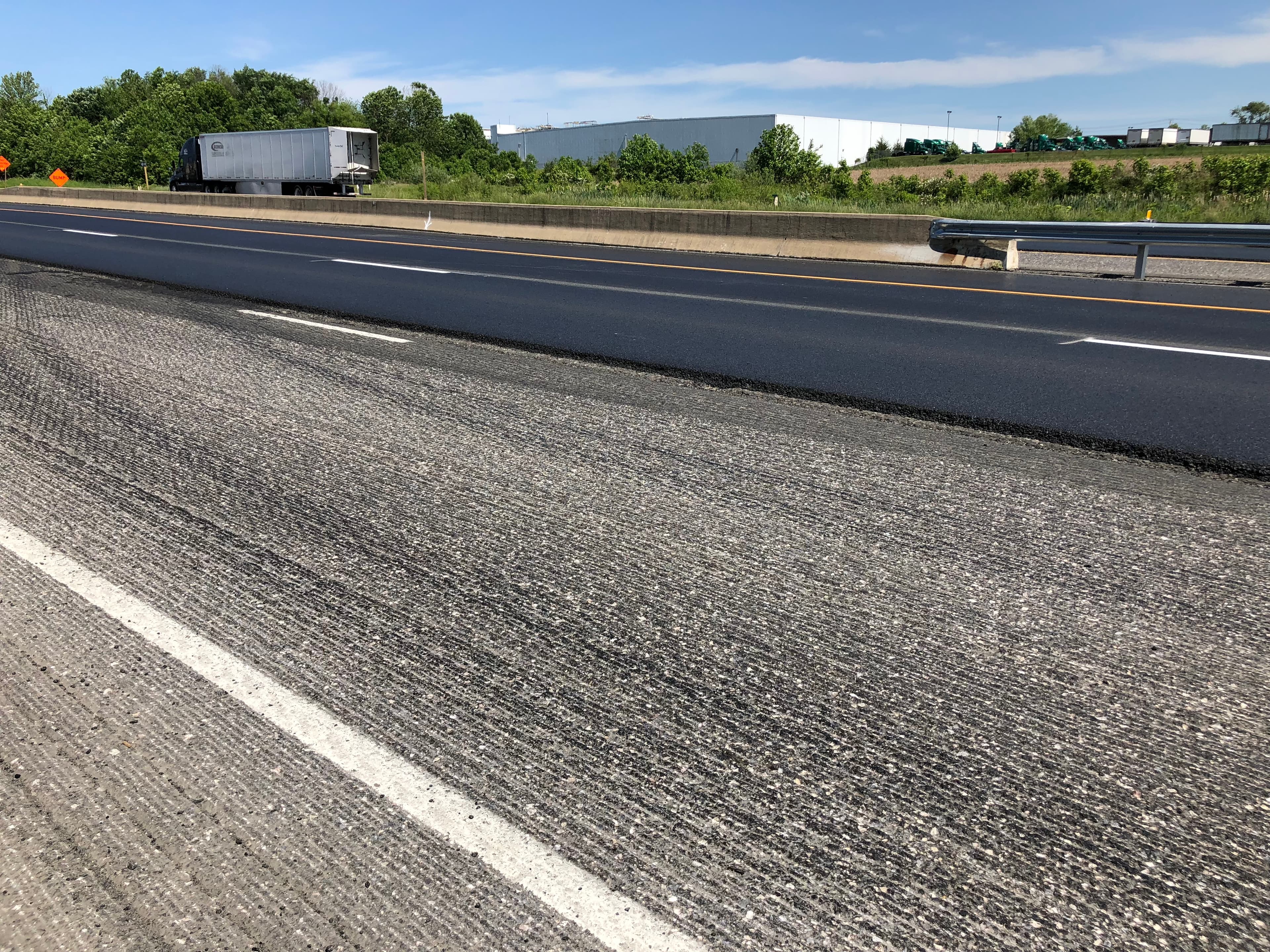 Asphalt paving machine working on a road in NJ service area